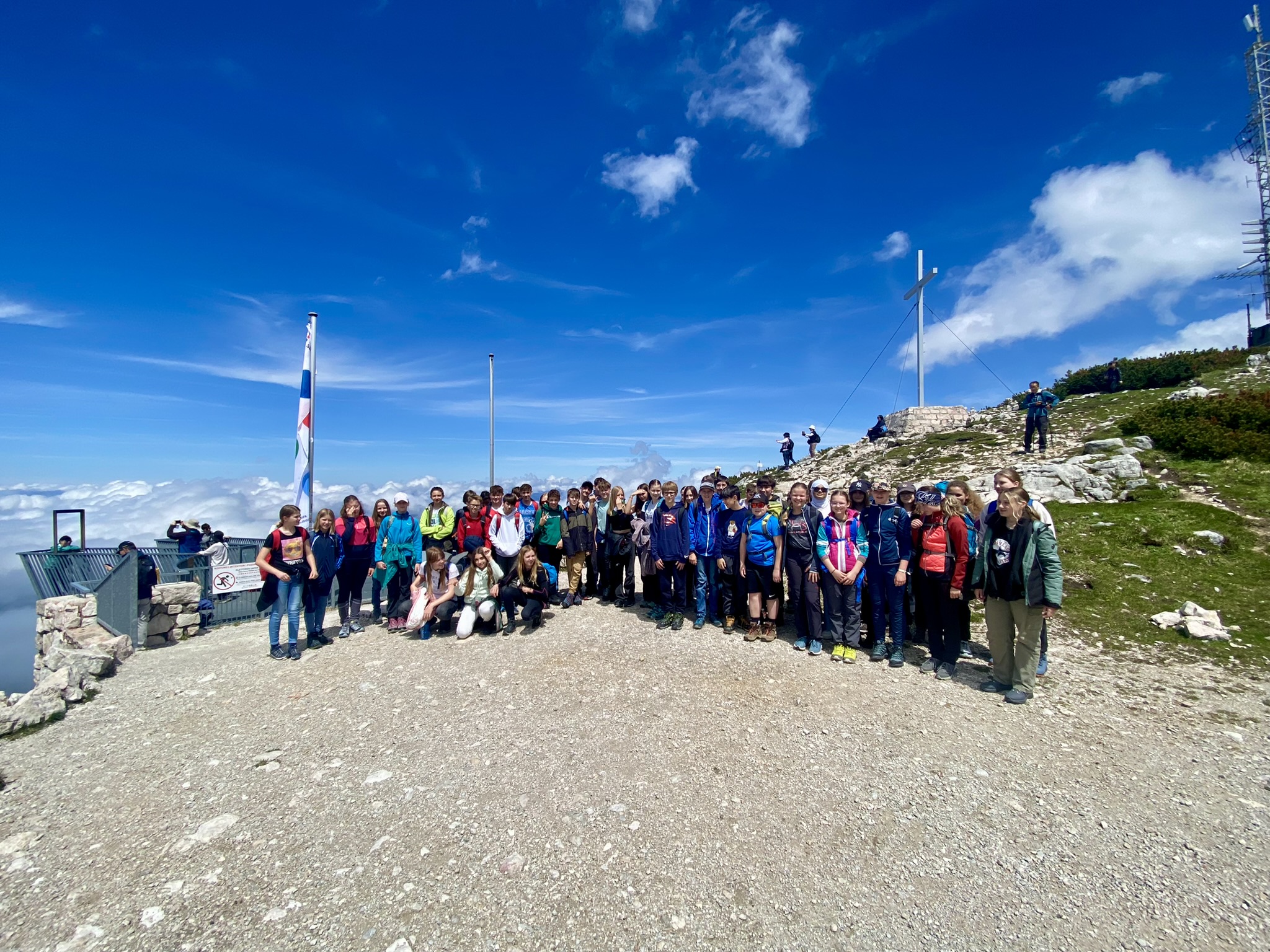 Eine Schülergruppe steht bei blauem Himmel in einem alpinen Szenario